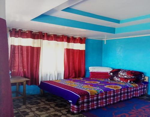 1 dormitorio con 1 cama en una habitación con paredes azules en Sona Homestay by StayApart, en Ghum
