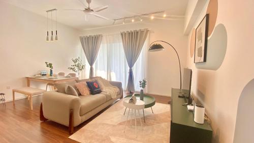 クアラルンプールにあるUNA Serviced Apartment by manatidurのリビングルーム(ソファ、テーブル付)