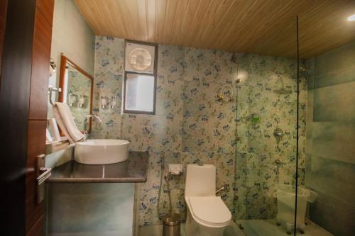 a bathroom with a toilet and a sink and a shower at Amritara The Avadh in Badrīnāth