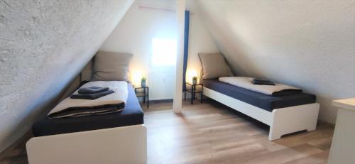 a attic room with two beds and a mirror at Monteurwohnung in Trossingen bei Villingen-Schwenningen in Trossingen