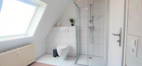 a white bathroom with a shower and a toilet at Monteurwohnung in Trossingen bei Villingen-Schwenningen in Trossingen