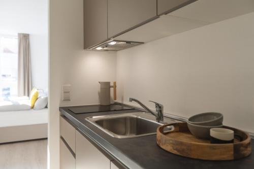 a kitchen with a sink with a bowl on the counter at acora Heidelberg Living the City - Apartments in Heidelberg