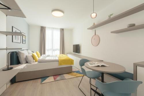 a bedroom with a bed and a table and chairs at acora Heidelberg Living the City - Apartments in Heidelberg