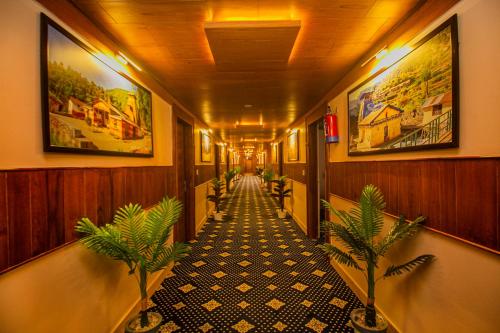 a hallway with potted plants and paintings on the walls at Amritara The Avadh in Badrīnāth