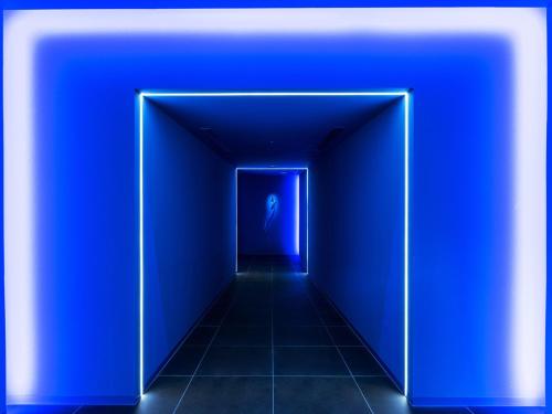 a blue corridor with a person walking into a blue door at Hotel Il Palazzo in Fukuoka
