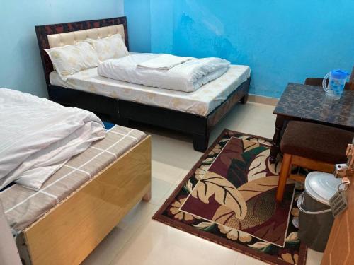 a room with two beds and a table and a table sidx sidx at Amardeep Homestay by StayApart in Ukhimath