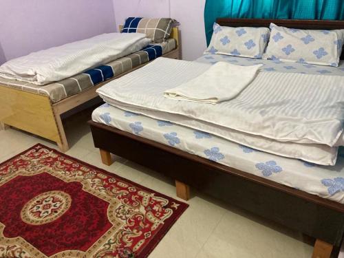 2 aparte bedden in een kamer met een tapijt bij Amardeep Homestay by StayApart in Ukhimath