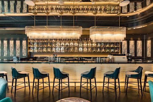 um bar num restaurante com cadeiras e luzes em SILQ Hotel & Residence, Managed by The Ascott Limited em Bangkok