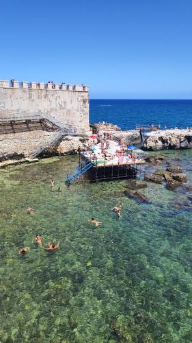 a group of people swimming in the water at Al Settimo porta marina in Siracusa