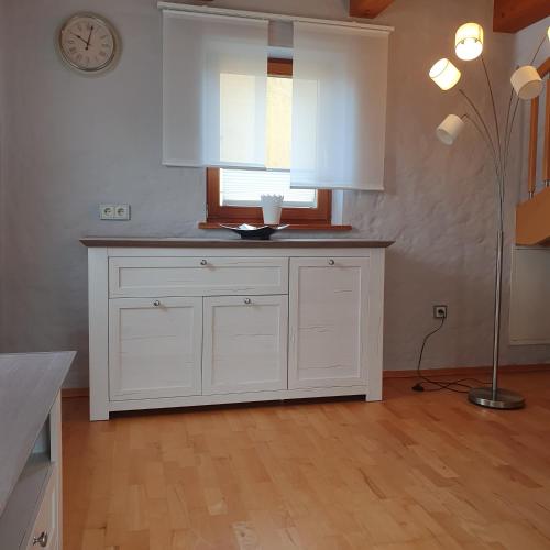een keuken met witte kasten en een raam en een lamp bij Ferienwohnung RELAX in Neudrossenfeld