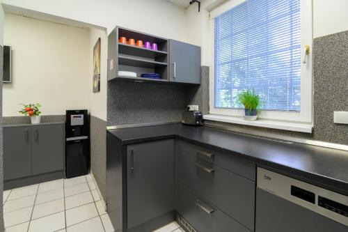 a kitchen with a black counter and a window at Hostel Seven in Prague