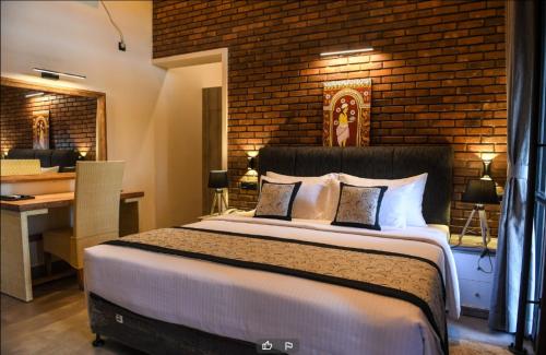 a bedroom with a bed with a brick wall at Abhaya Mandapa in Anuradhapura