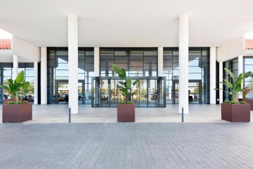 un bâtiment avec des colonnes et des plantes dans une cour dans l'établissement Hotel Best Costa Ballena, à Costa Ballena