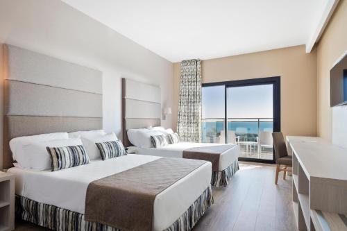 a hotel room with two beds and a large window at Hotel Best Costa Ballena in Costa Ballena