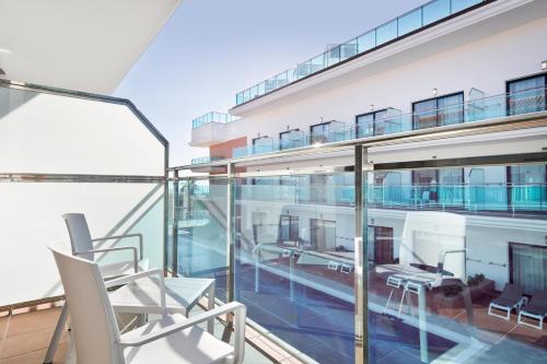 a balcony with chairs and tables on a building at Hotel Best Costa Ballena in Costa Ballena