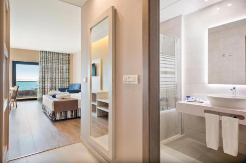 a bathroom with a sink and a mirror and a bedroom at Hotel Best Costa Ballena in Costa Ballena