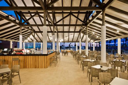 a dining hall with tables and chairs and a bar at Hotel Best Costa Ballena in Costa Ballena