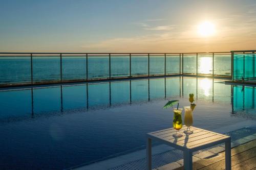a pool with a table with two glasses on it at Hotel Best Costa Ballena in Costa Ballena