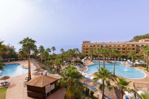 einen Luftblick auf ein Resort mit zwei Pools und Palmen in der Unterkunft Apartamentos Best Alcazar in La Herradura