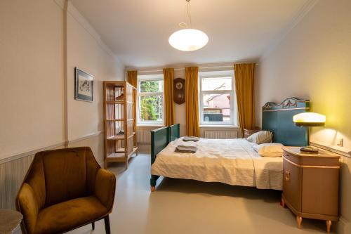 1 dormitorio con 1 cama y 1 silla en The Pearl, en Riga