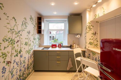 una pequeña cocina con armarios verdes y una ventana en The Pearl, en Riga