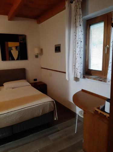 niewielka sypialnia z łóżkiem i oknem w obiekcie Villa Mola Bed And Breakfast w mieście Corbara