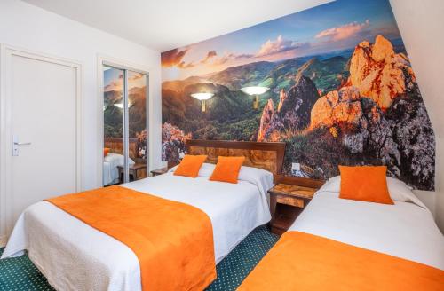 Duas camas num quarto com um mural de montanha em Hotel Terminus Montparnasse em Paris