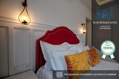 1 cama con cabecero rojo y algunas almohadas en Blue Mosque Suites 2 - Old City Sultanahmet, en Estambul