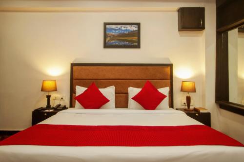 a bedroom with a large bed with red pillows at Amritara The Avadh in Badrīnāth