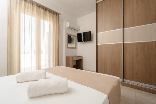een slaapkamer met een bed met twee handdoeken erop bij Evripus Suites in Kastraki Naxou