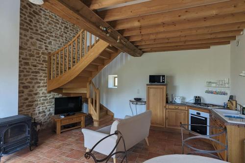 sala de estar con escalera y cocina en Maison Cosy - Normandie - Haras du Pin 30', en Fay