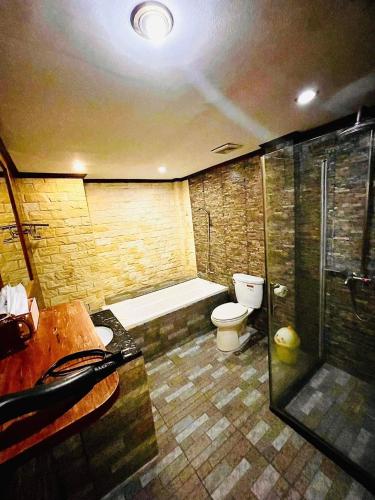 a bathroom with a tub and a toilet and a shower at Vieng Savanh II Hotel in Luang Prabang