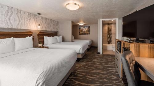 a hotel room with two beds and a flat screen tv at Aiden by Best Western St George in St. George