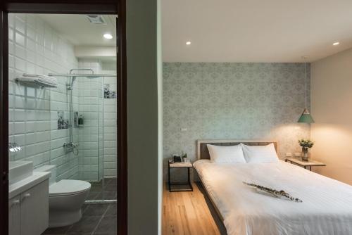 魚池鄉的住宿－巧人文旅民宿，一间卧室配有一张床,浴室设有淋浴。