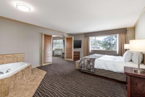 a hotel room with a bed and a bath tub at Prestige Radium Hot Springs Resort, WorldHotels Crafted in Radium Hot Springs