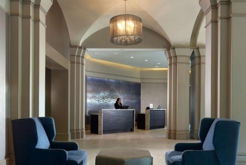 a man sitting at a desk in a lobby at Hilton Atlanta Northeast in Norcross