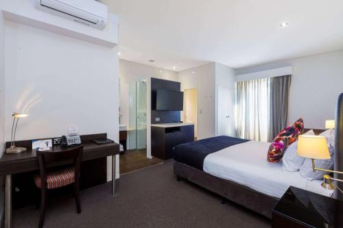 a hotel room with a bed and a desk at Club Wyndham Perth, Trademark Collection by Wyndham in Perth