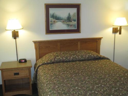 a bedroom with a bed and a picture on the wall at Bozeman Inn in Bozeman