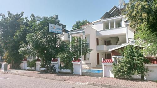 a building with a sign in front of it at London House Hotel in Kemer