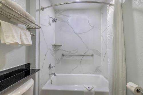 a white bathroom with a tub and a shower at Motel 6-Fort Worth, TX - Burleson in Fort Worth