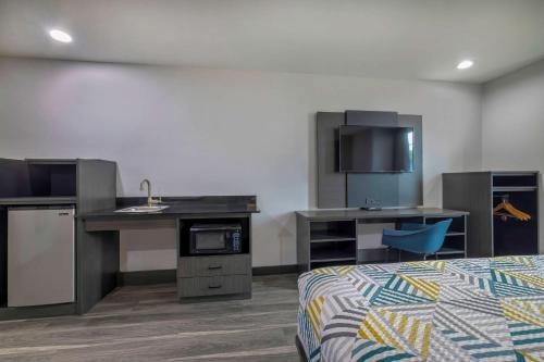 a room with a bed and a kitchen with a sink at Motel 6-Fort Worth, TX - Burleson in Fort Worth