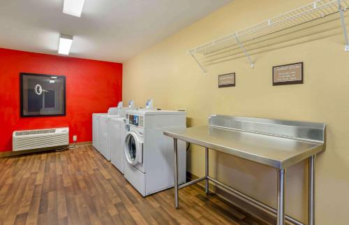 a laundry room with a washing machine and red wall at Extended Stay America Suites - Lynchburg - University Blvd in Lynchburg