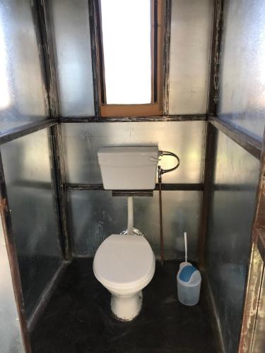 a small bathroom with a toilet and a window at Moae Campsite 
