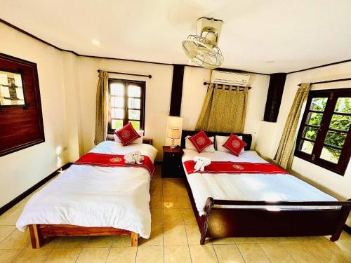 a bedroom with two beds with red and white sheets at Vieng Savanh II Hotel in Luang Prabang