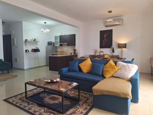 a living room with a blue couch and a table at Paramount Gardens Resorts D204 in Tersephanou