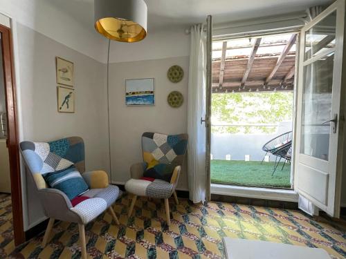 - un salon avec deux chaises et une fenêtre dans l'établissement Maison Petit Arago avec roof terrace et parking privé, à Carcassonne