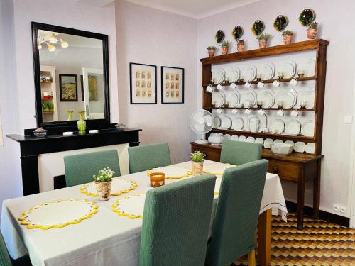 ein Esszimmer mit Tisch und Stühlen und einem Spiegel in der Unterkunft Maison Petit Arago avec roof terrace et parking privé in Carcassonne