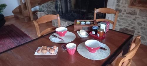 une table en bois avec des assiettes de nourriture dessus dans l'établissement La MÉSANGE BLEUE, à Écuras