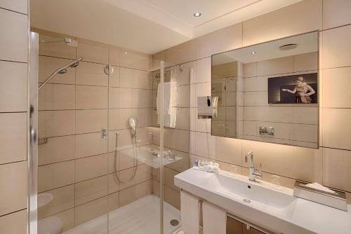 a bathroom with a shower and a sink and a mirror at Radisson Blu Hotel Milan in Milan