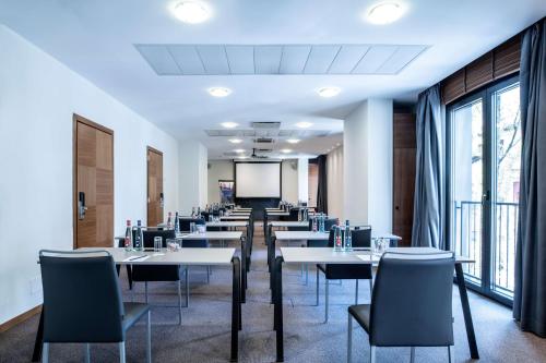 a conference room with tables and chairs and a screen at Radisson Blu Hotel Milan in Milan
